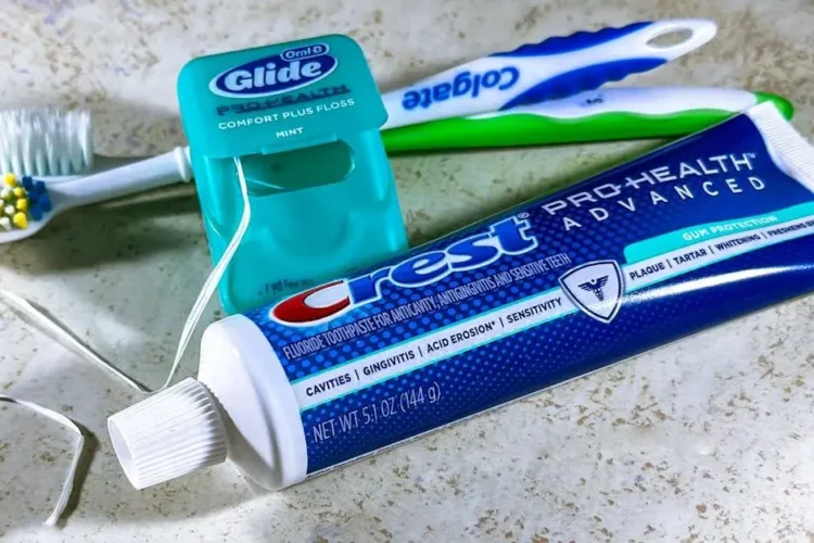 Dental hygiene tools for plaque removal: floss, toothpaste, and toothbrushes.