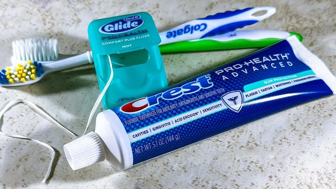 Dental hygiene tools for plaque removal: floss, toothpaste, and toothbrushes.