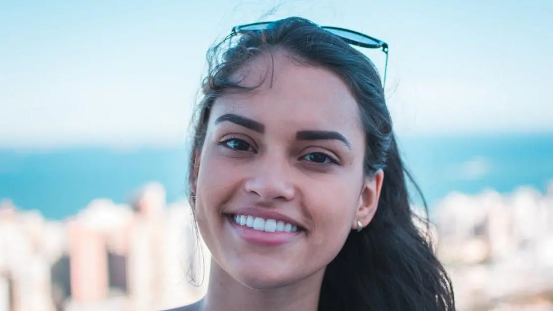 Smiling woman showcasing porcelain veneers procedure results