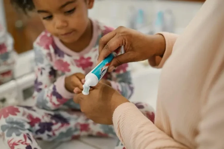 Mother preparing daughter for first dental visit, emphasizing dental care.