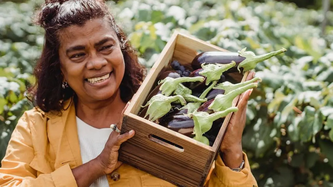 Middle-aged woman carrying fresh eggplants, symbolizing preventing orthodontic problems through healthy eating