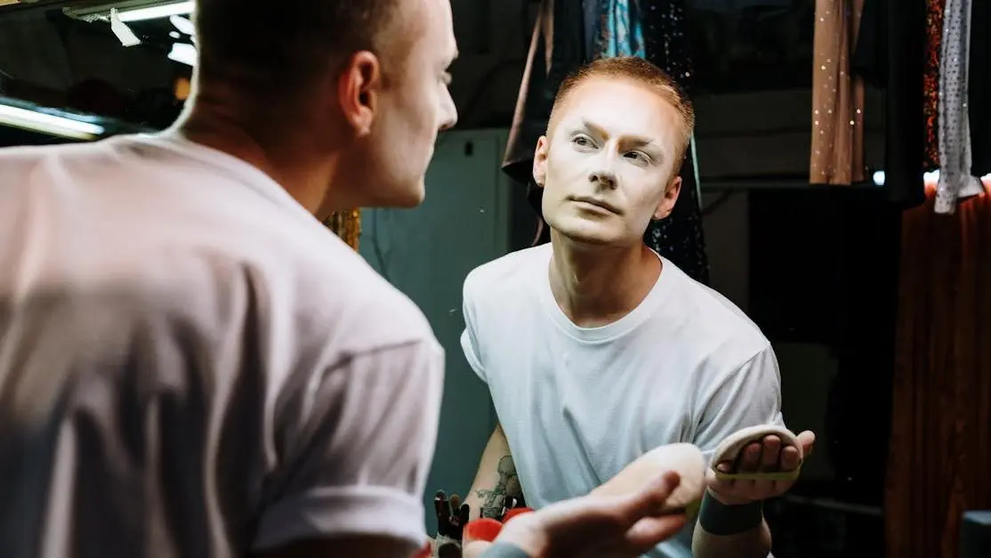 Drag queen applying makeup related to prosthodontics.