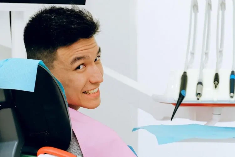 Smiling man in dental chair, preparing for treatment with safe deep sedation dentist