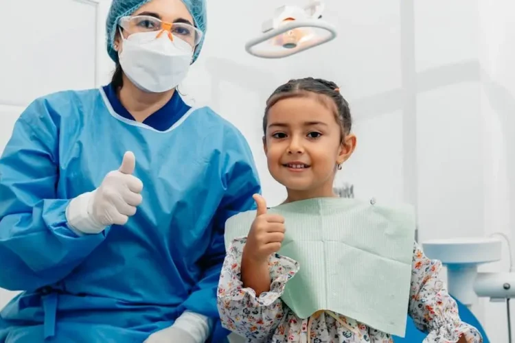 Dentist with child patient smiling, promoting sedation dentistry for kids