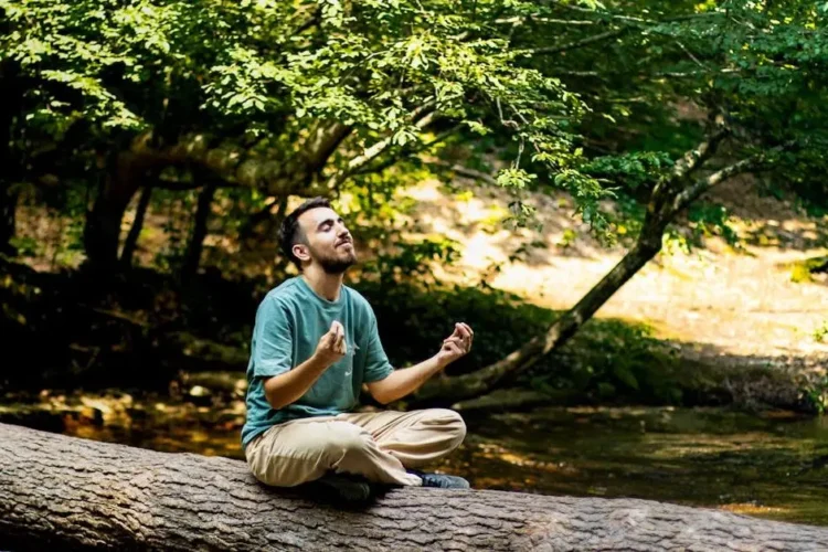 Meditating man in forest, related to sedation dentistry for phobia.