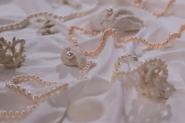 Pearl necklaces displayed on white cloth.