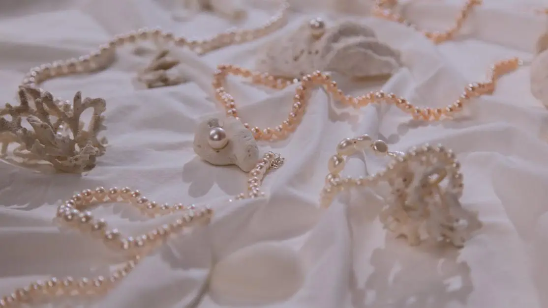 Pearl necklaces displayed on white cloth.