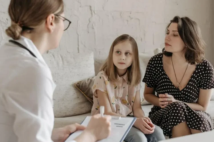 Dentist consulting with a mother and daughter for specialist dental care near me