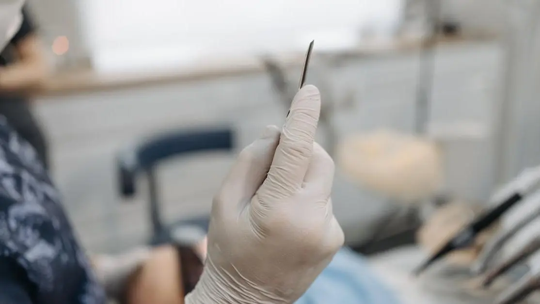 Gloved hands of a specialist preparing dental implants