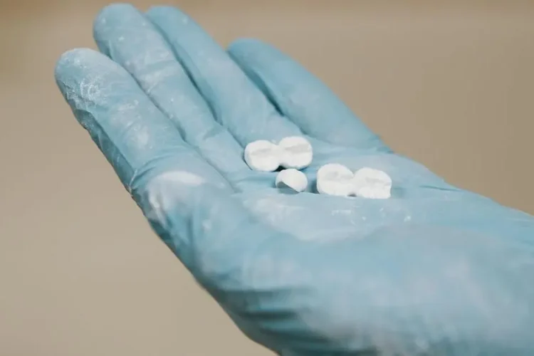 Various types of dental implants materials held by a gloved hand.