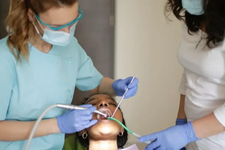 Dentist and assistant working on patient with different types of retainers.