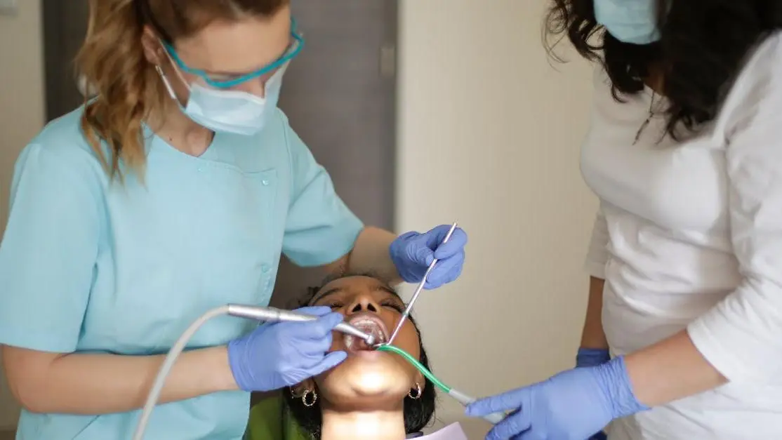 Dentist and assistant working on patient with different types of retainers.