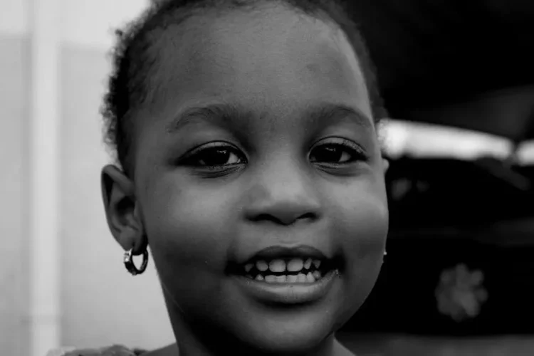 Girl smiling, showing white spots on teeth.