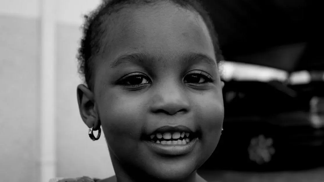 Girl smiling, showing white spots on teeth.