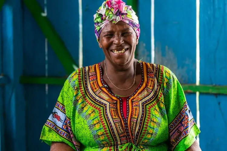 Smiling woman showcasing the benefits of dental implants.