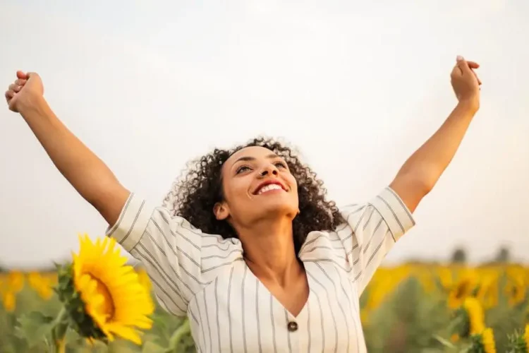 Joyful woman celebrating freedom, illustrating the benefits of dental implants.