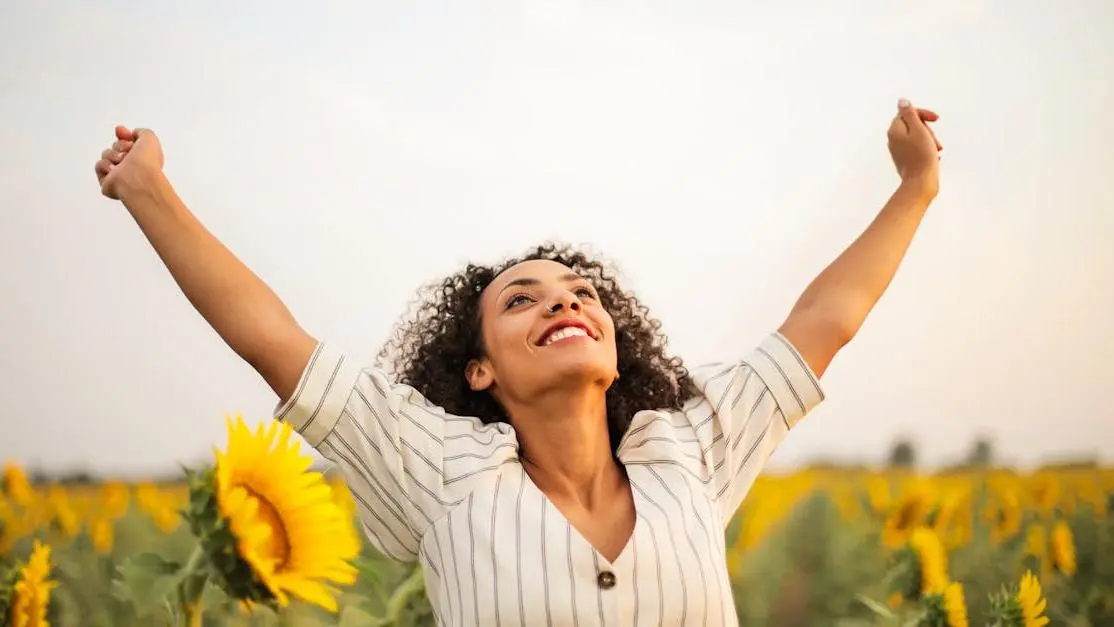 Joyful woman celebrating freedom, illustrating the benefits of dental implants.