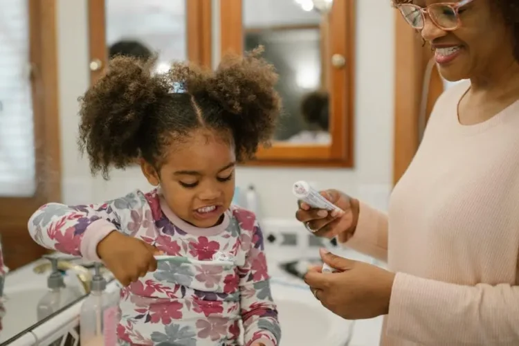 Mother and daughter practicing best dental care for kids during morning routine.