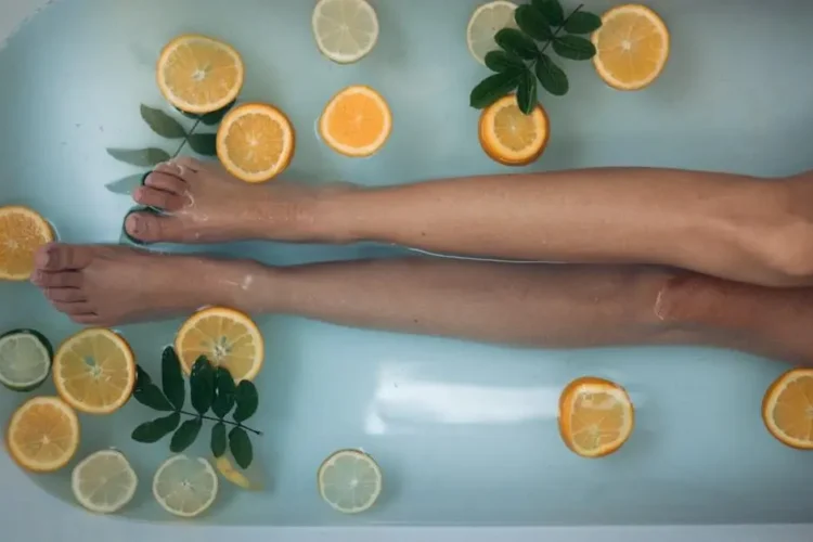 Hand holding sliced orange, related to canker sores.