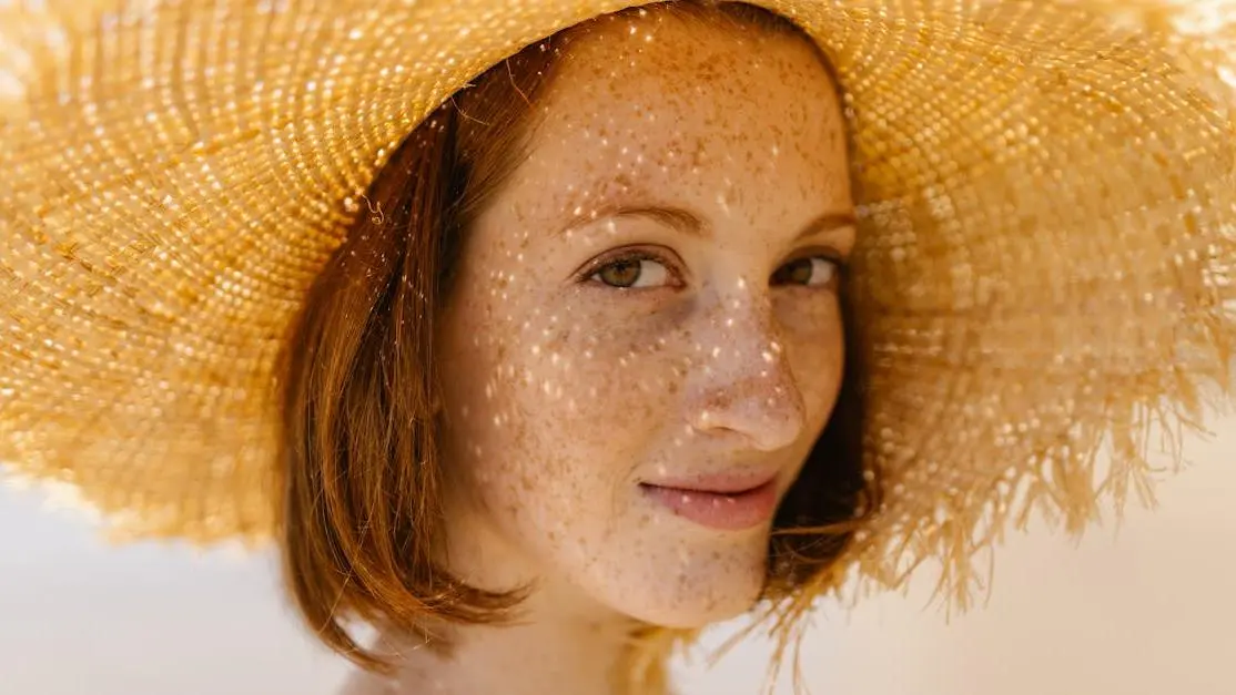 Smiling woman outdoors with straw hat, highlighting healthy front teeth.