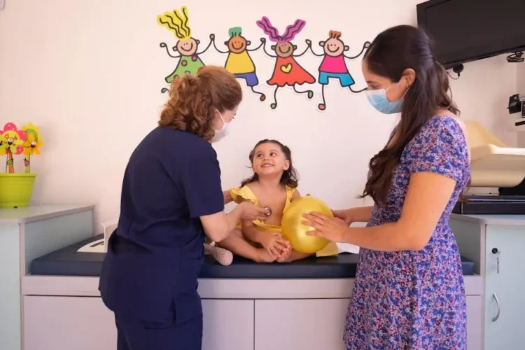 Doctor checking a young child at a pediatric clinic, illustrating the process of choosing a pediatric dentist.