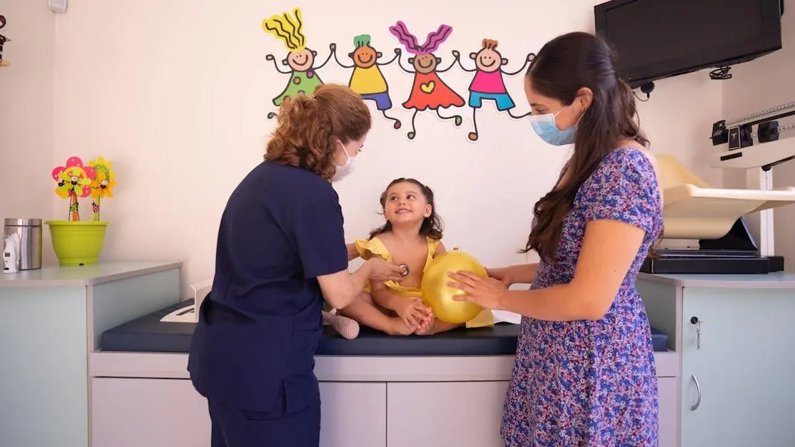 Doctor checking a young child at a pediatric clinic, illustrating the process of choosing a pediatric dentist.