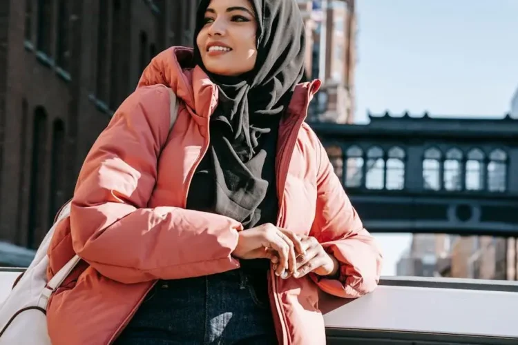 Smiling woman in hijab on city bridge, symbolizing dental bridges.