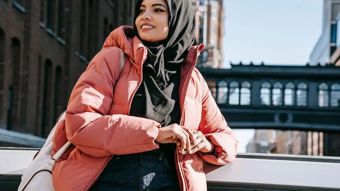 Smiling woman in hijab on city bridge, symbolizing dental bridges.