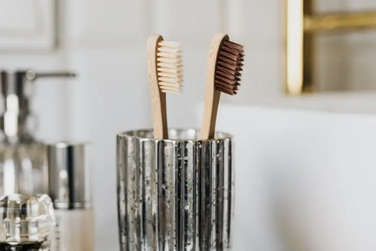 Eco-friendly bamboo toothbrushes for dental hygiene tips for a healthy smile near bathroom sink.