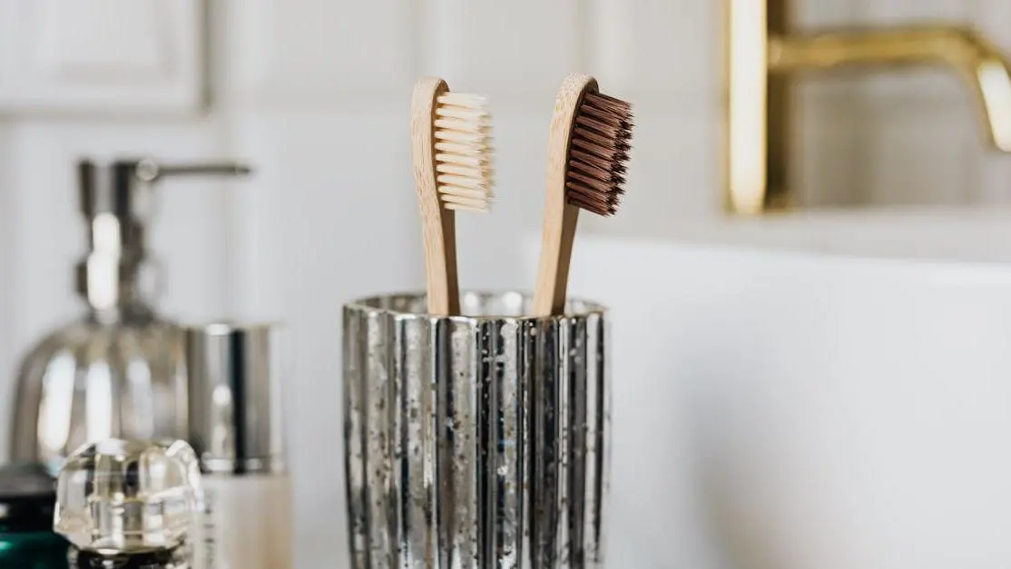 Eco-friendly bamboo toothbrushes for dental hygiene tips for a healthy smile near bathroom sink.