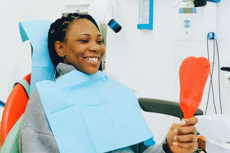 Smiling woman examining dental implants during a check-up, showcasing Cookstown dental implant services.