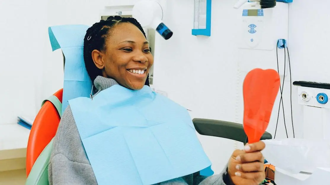 Smiling woman examining dental implants during a check-up, showcasing Cookstown dental implant services.