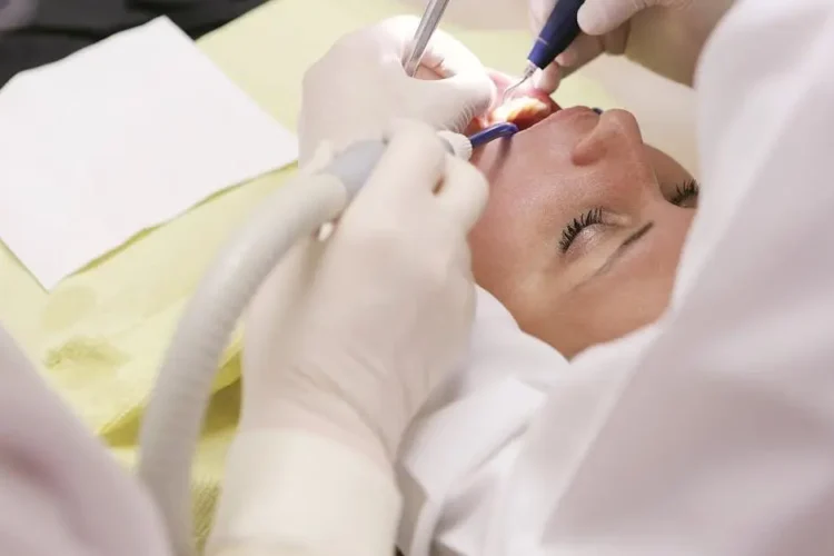 Dentist flossing teeth of a patient in a dental clinic