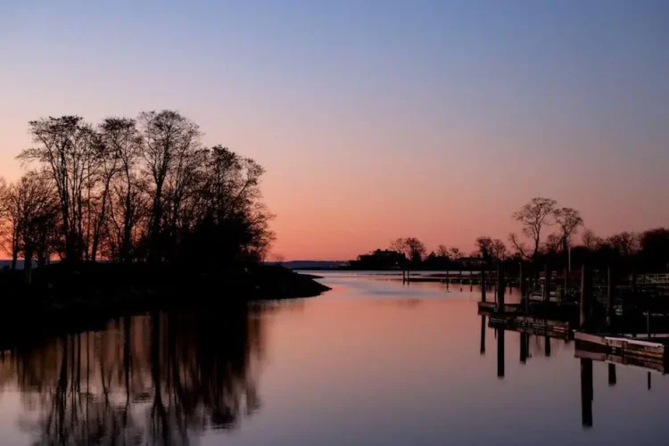 Sunset over Cove Island Park river with a wooden pier, illustrating fluoride safety context.