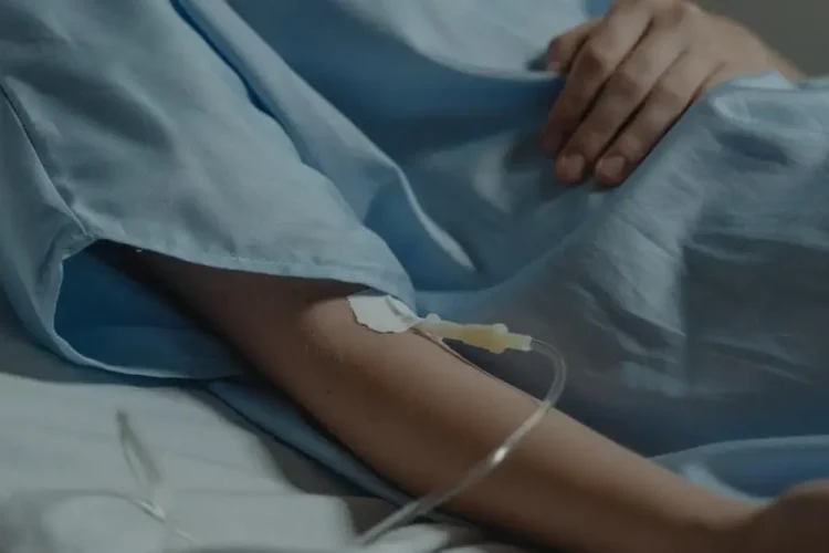 Patient in hospital bed with IV drip, highlighting IV sedation safety.