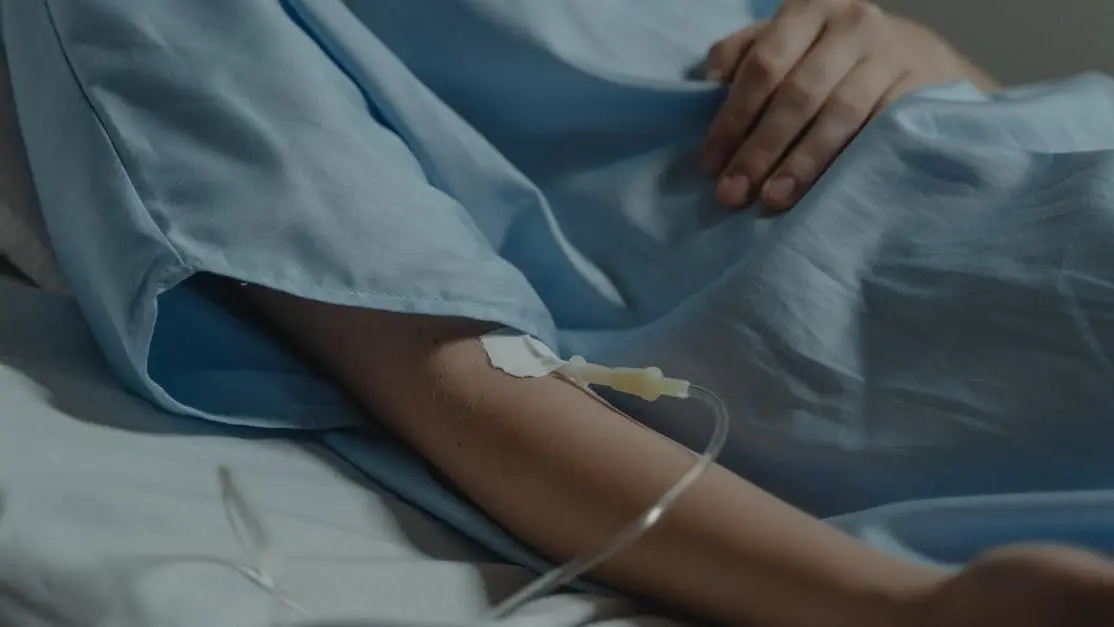 Patient in hospital bed with IV drip, highlighting IV sedation safety.