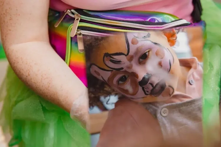 Child exploring face paint in mirror, illustrating kids dental health misconceptions.