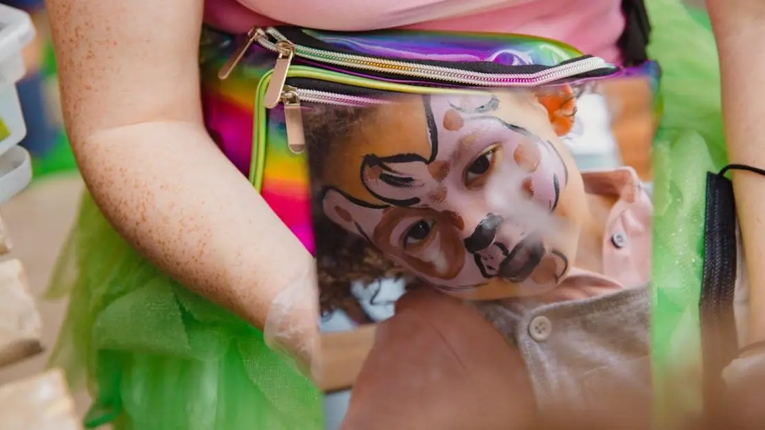 Child exploring face paint in mirror, illustrating kids dental health misconceptions.