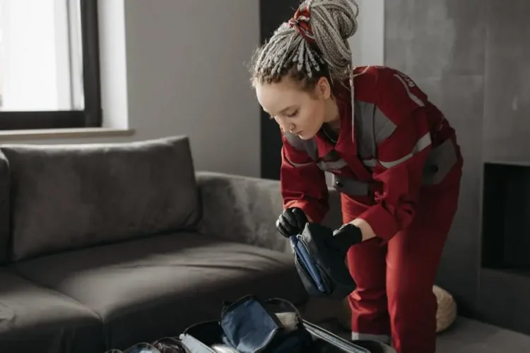 Paramedic prepares medical kit for managing dental emergencies at home indoors.