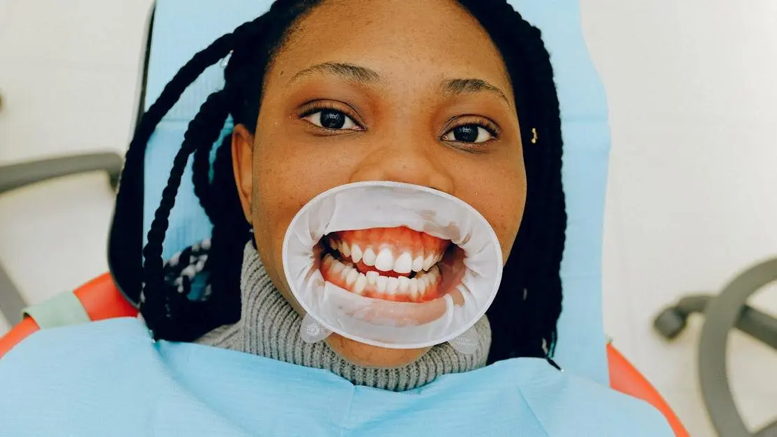 Dental exam showing woman's open bite with cheek retractor.