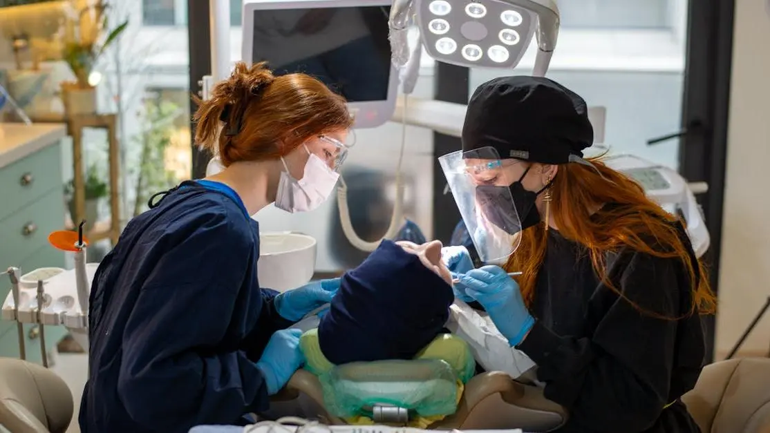 Dentist performing oral and maxillofacial surgery with assistant in a dental clinic