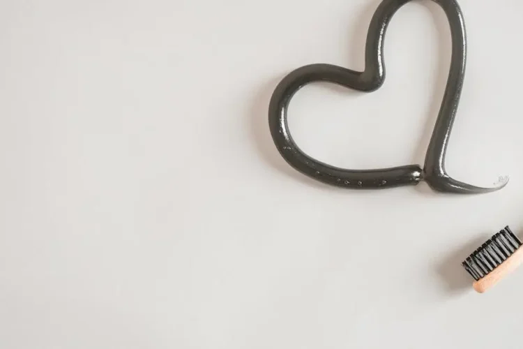 Toothbrush with toothpaste heart symbolizing oral health and heart health correlation