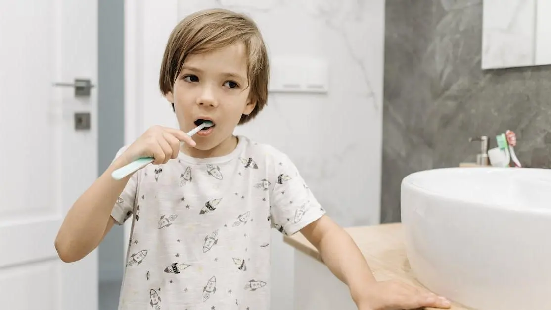 Young boy brushing teeth, promoting oral health education.