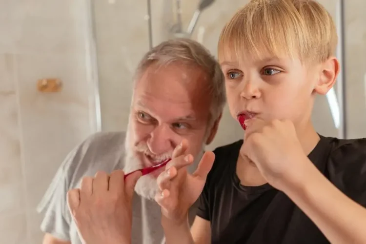 Grandfather teaches grandson dental hygiene, showcasing oral health tips for kids and adults.