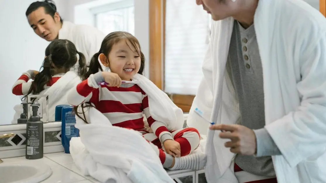 Father and daughter practicing preventive dental care for families in a cozy bathroom.