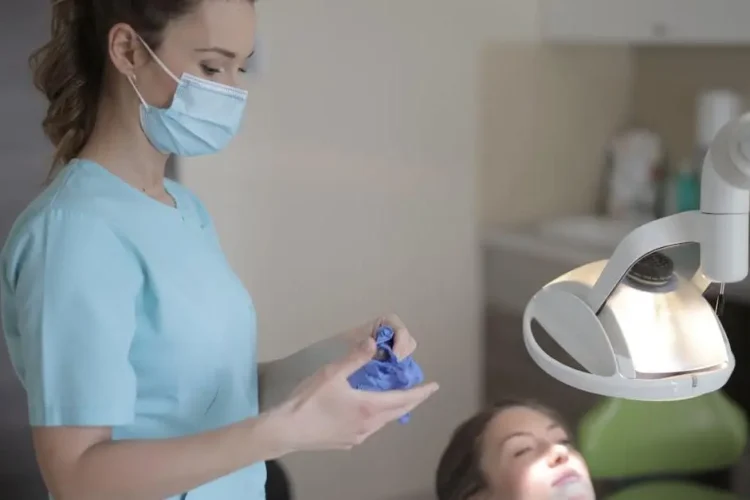 Dentist removing gloves after root canal therapy in clinic