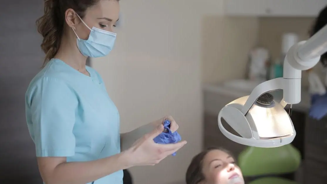 Dentist removing gloves after root canal therapy in clinic