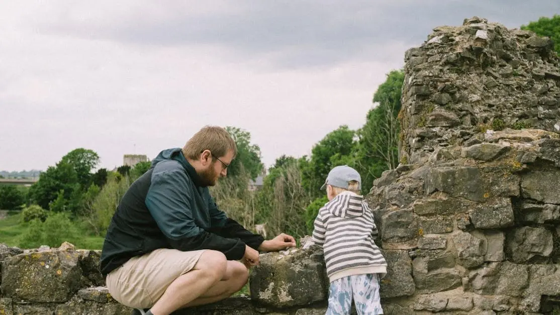 Man and child exploring ancient stone ruins, illustrating the tell show do method in learning.