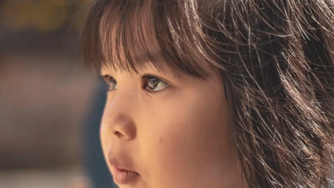 Young girl with brown eyes demonstrating tongue thrusting.