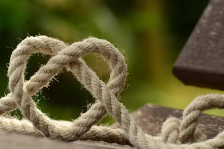 Heart-shaped twine on rustic wooden table symbolizing tongue tie.